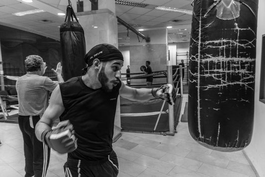 Boxer practicing right-hook combination on a punching bag at home.